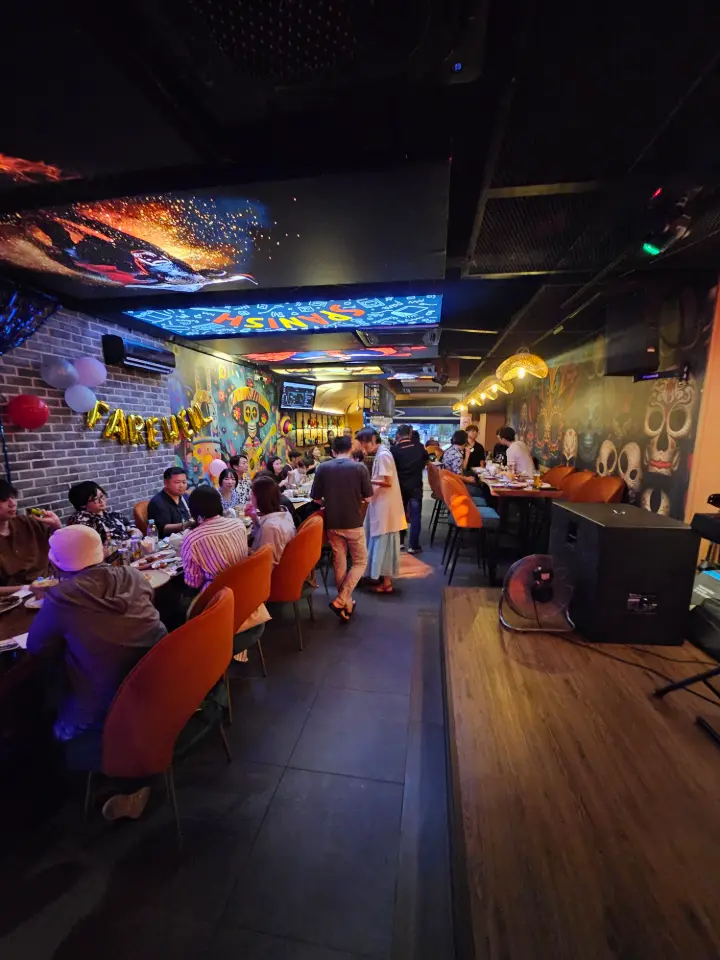 Guests mingling in the neon-lit room