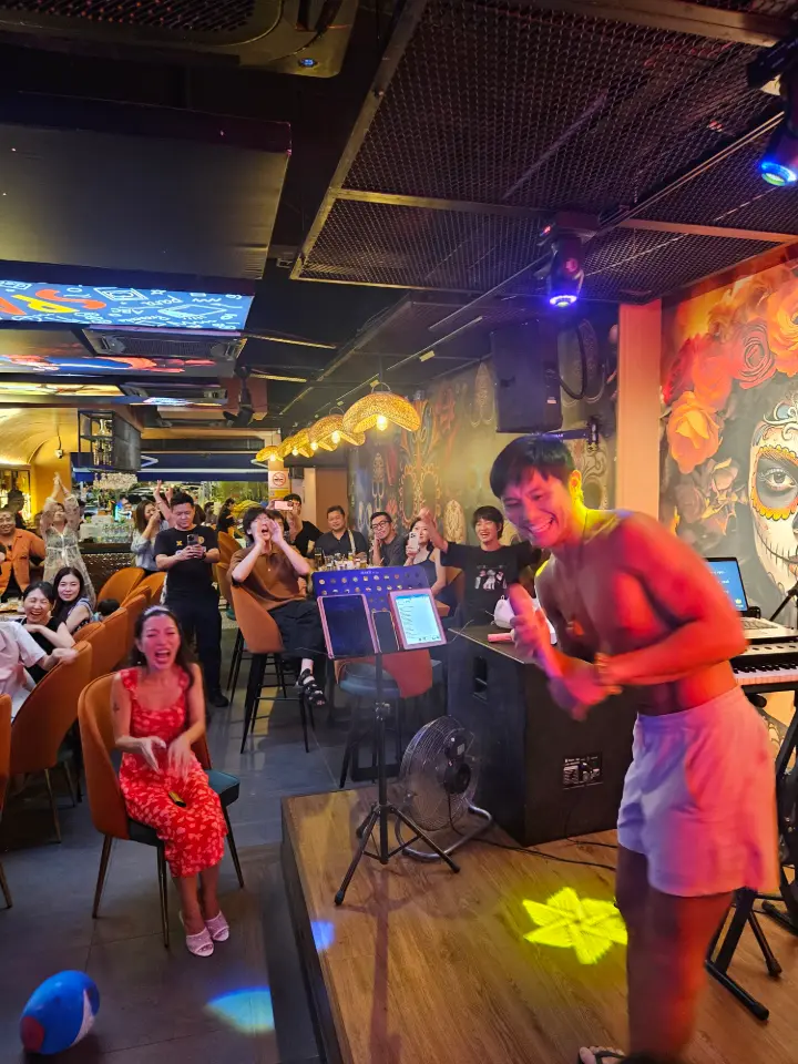 Crowded room under bright neon signage