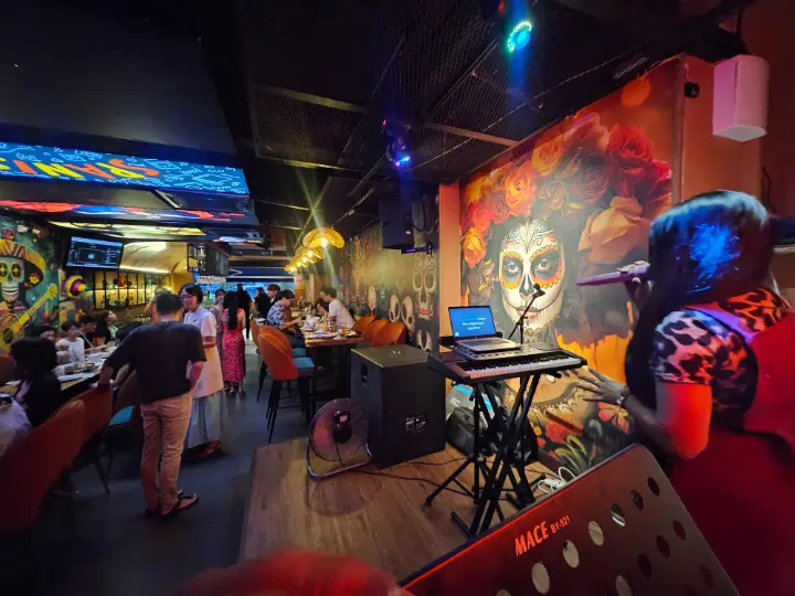 La Vida interior packed with guests, glowing neon and the live band set up